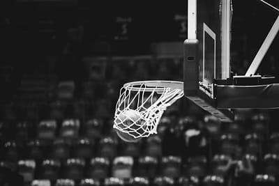 A ball dropping through a basketball net in an empty arena